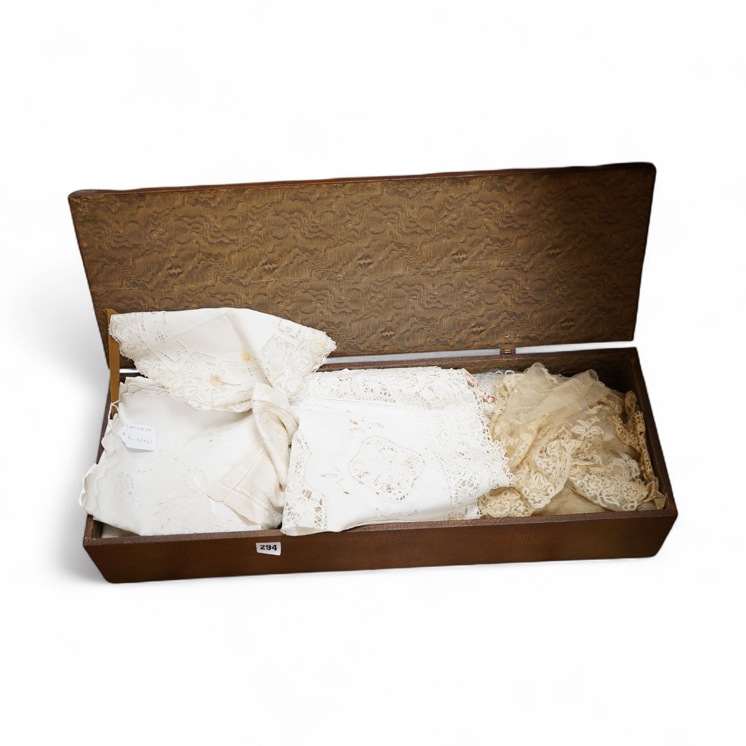 A small box/trunk containing mixed crochet, embroidered anglaise and drawn thread table linens, christening gown, damask cloths and various pieces of lace etc.Ornate circular cloth 112cm diameter. Condition - most need r